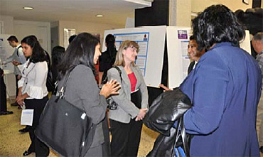photo: Mary Kicza (center); Priti Brahma (far right) speaking with students at the poster session
