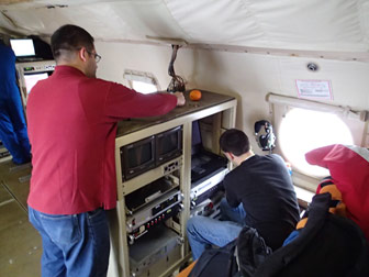 Suleiman Alsweiss and Joseph Sapp working on the IWRAP instrumentation on the NOAA P-3