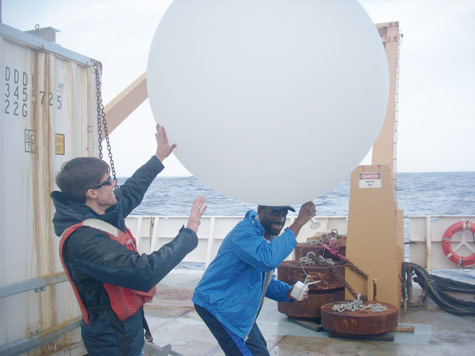 Stephen Demetry and Jonathan Smith inflates a balloon that will measure wind, pressure and temperature in an atmospheric river. (photo: Nick Nalli)